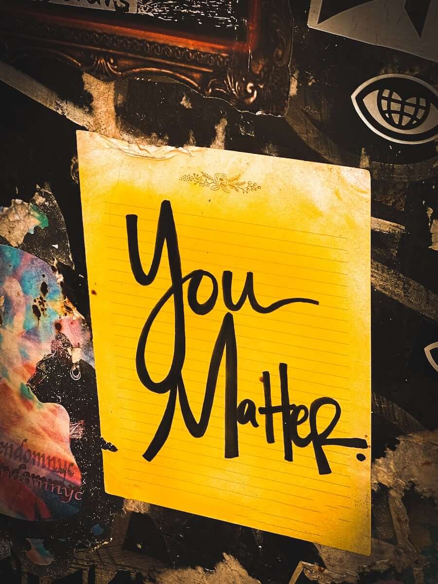 Eine gelbe Notiz mit den Worten "You Matter" an einer Wand.