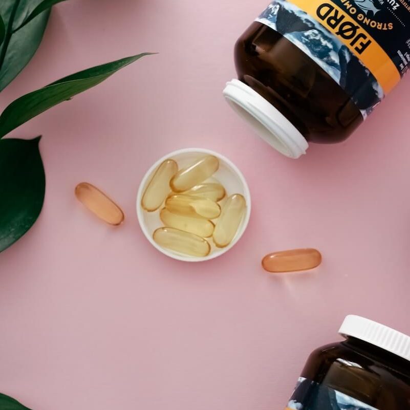 Omega 3 Fettsäuren - in Form von Kapseln auf rosa Hintergrund